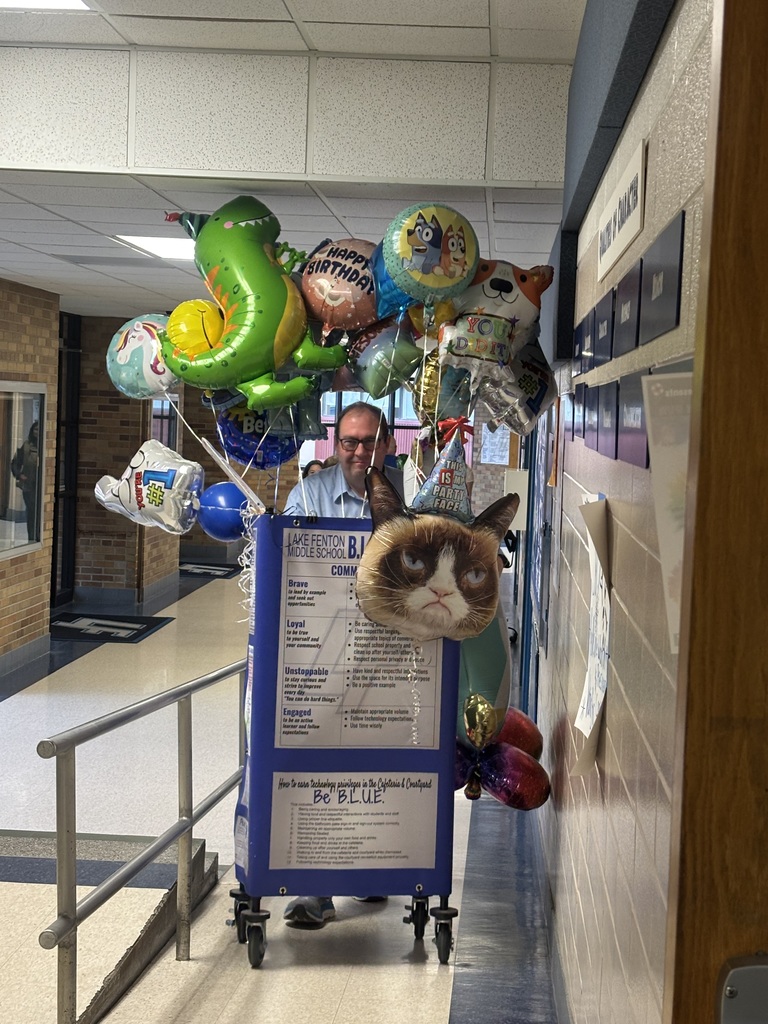 principal posing with balloons