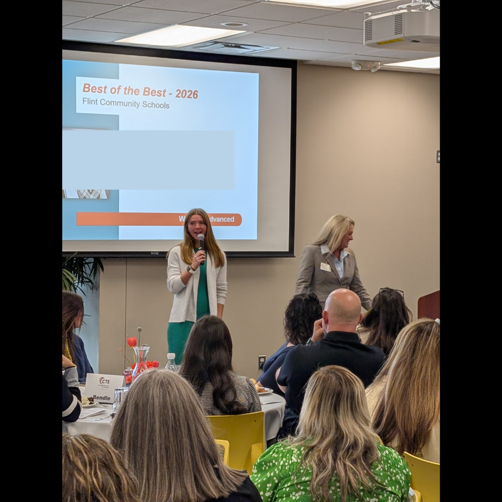 Girl speaking in front of a room full of people