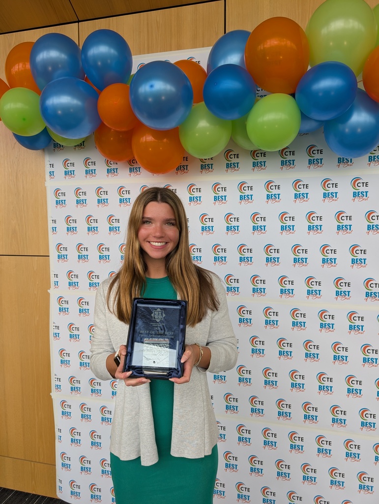 girl holding an award plaque in front of colorful backdrop