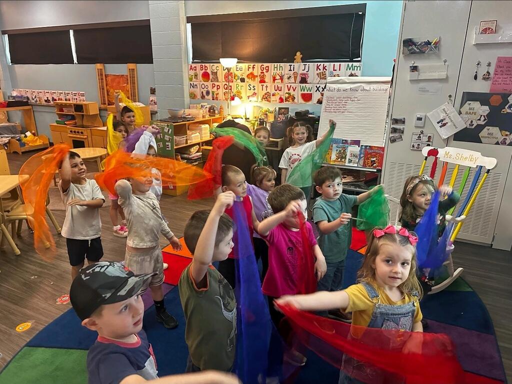 preschool students playing with scarves