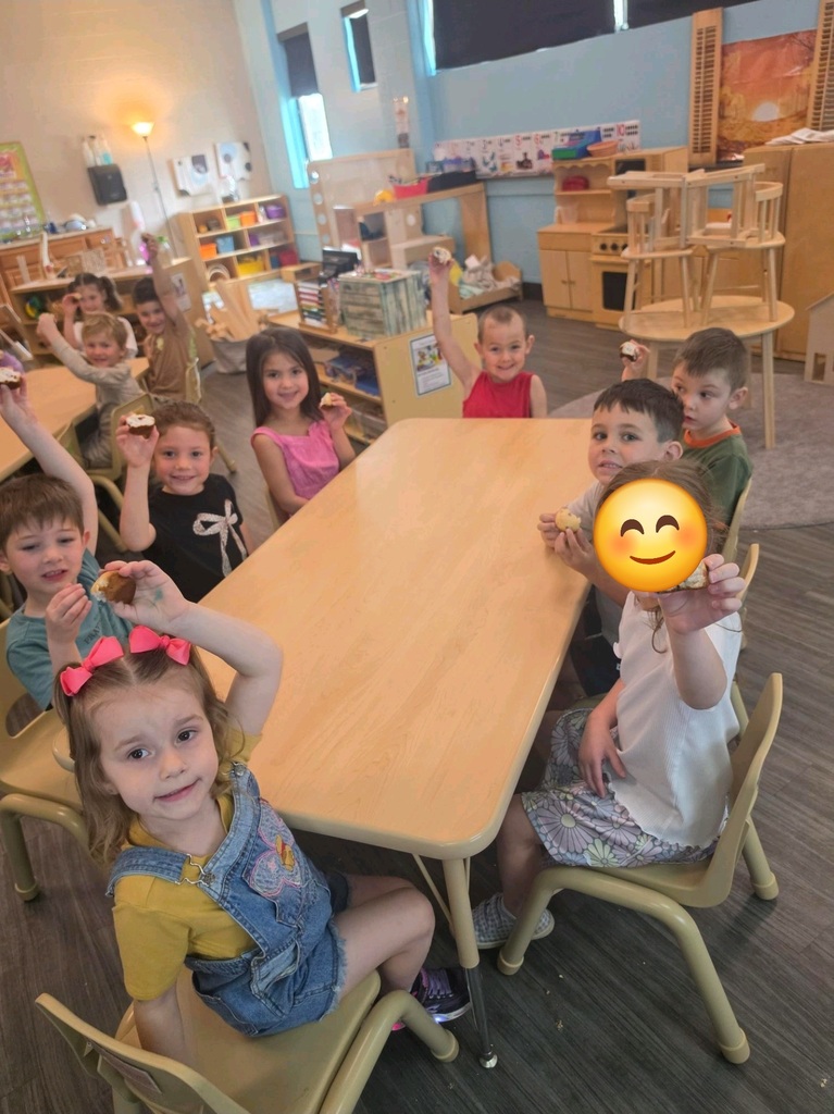preschool students sitting at tables in a classroom