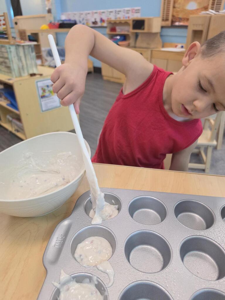 preschool student playing with a spoon and dough