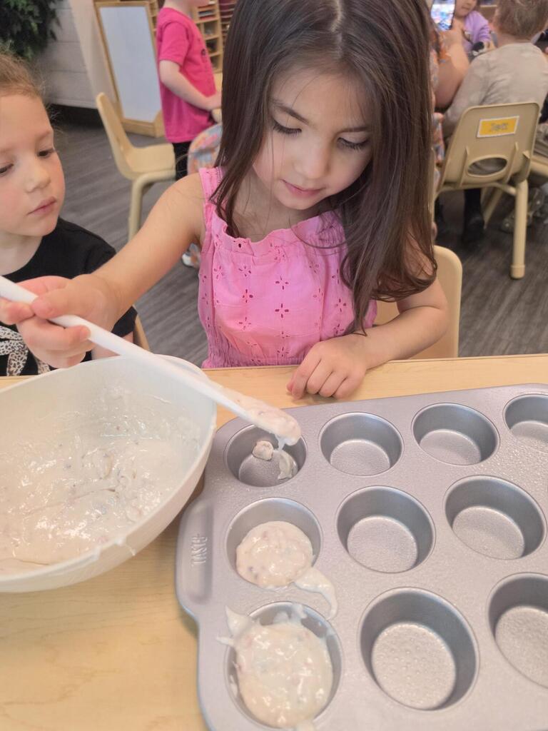 preschool student playing with a spoon and dough