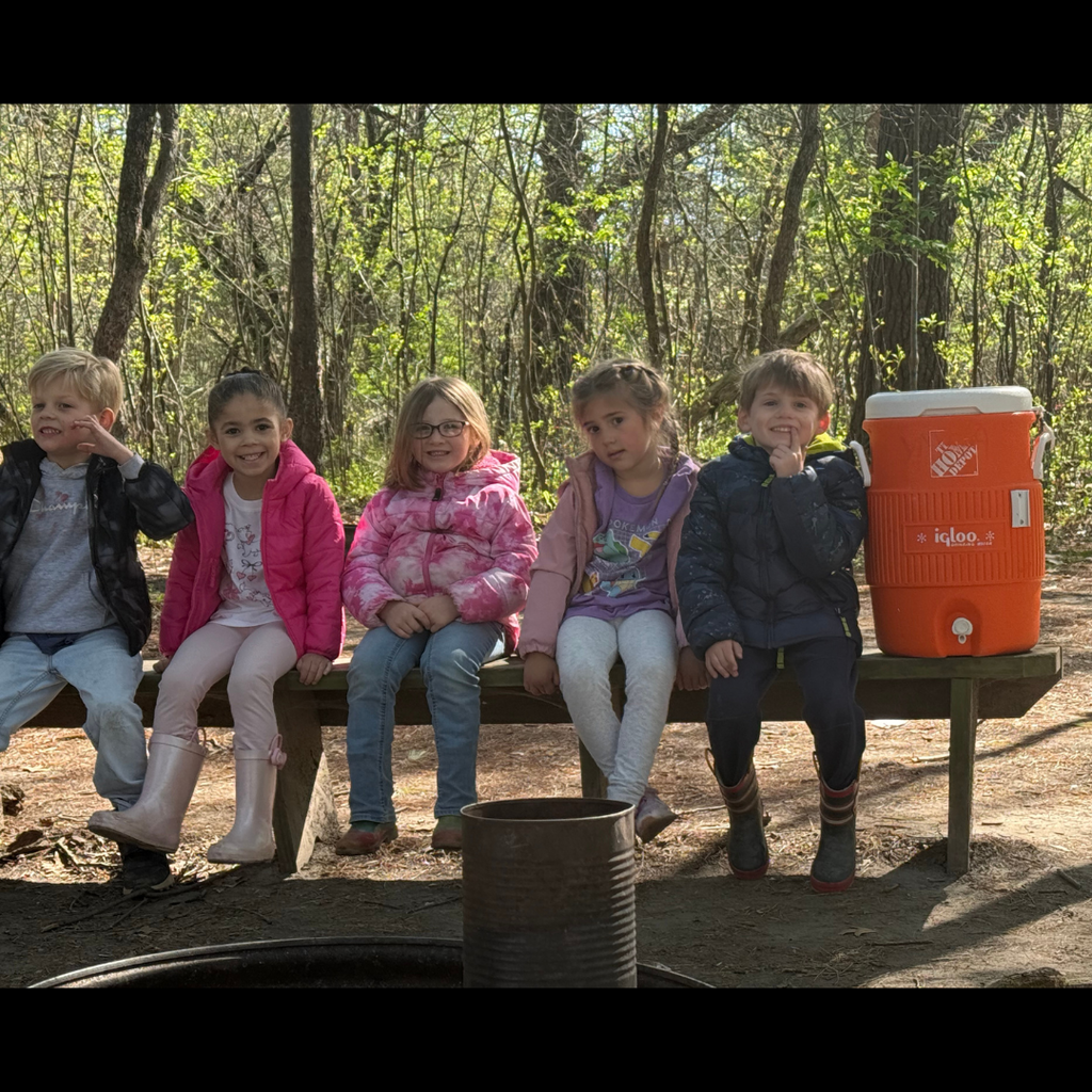 group of kids posing on a bench outside