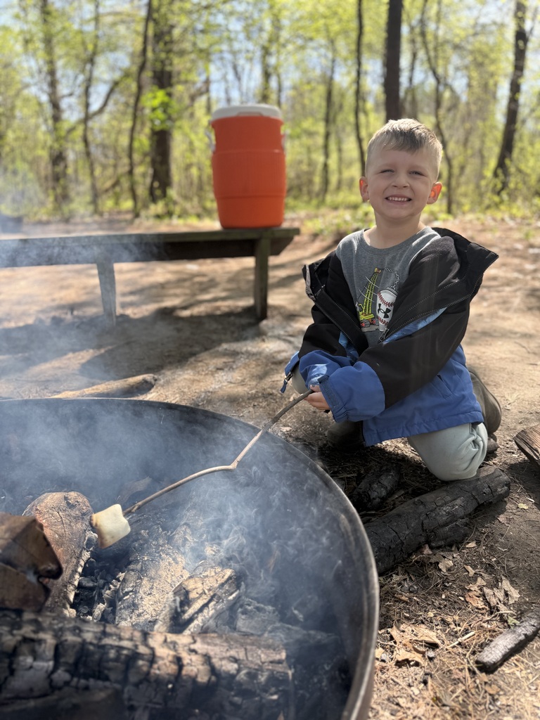 little boy roasting a marshmallow
