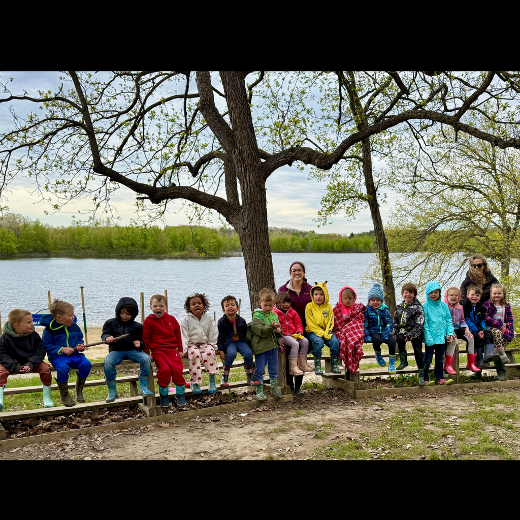 large group of kids posing in front of a lake
