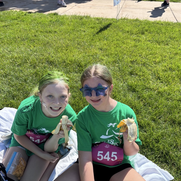 2 girls posing in green shirts 