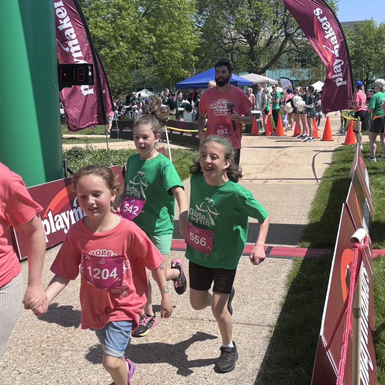 girls running across a finish line  