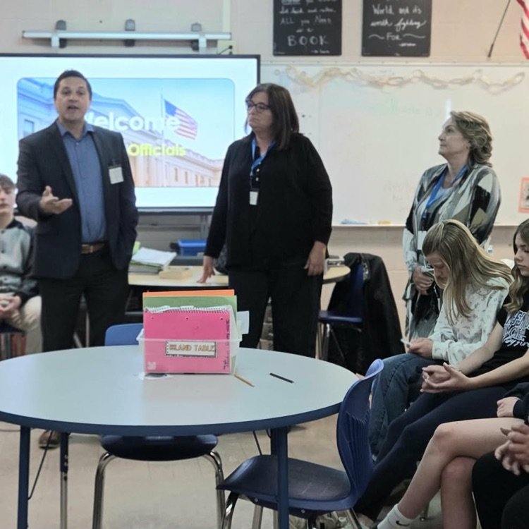 adults speaking in a classroom of kids