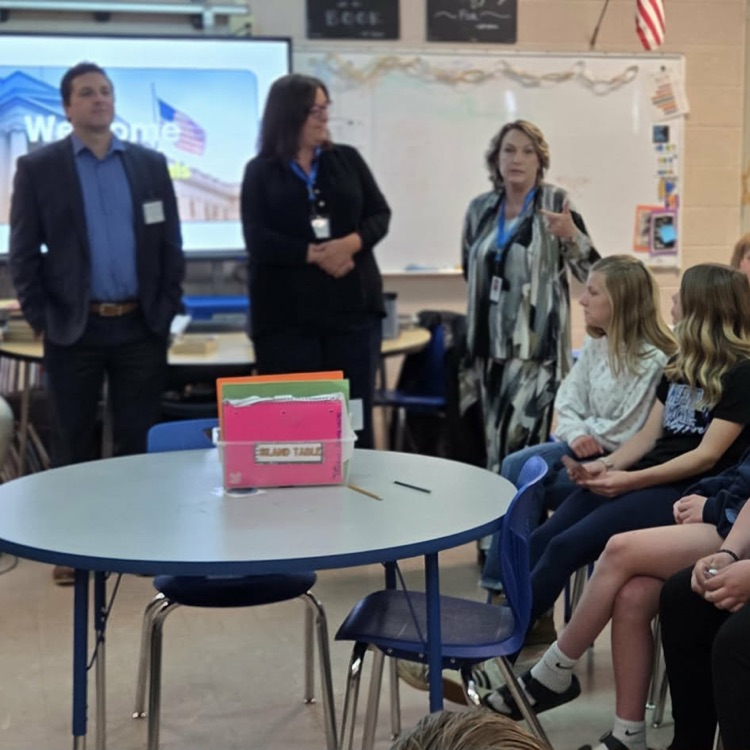 adults speaking in a classroom of kids