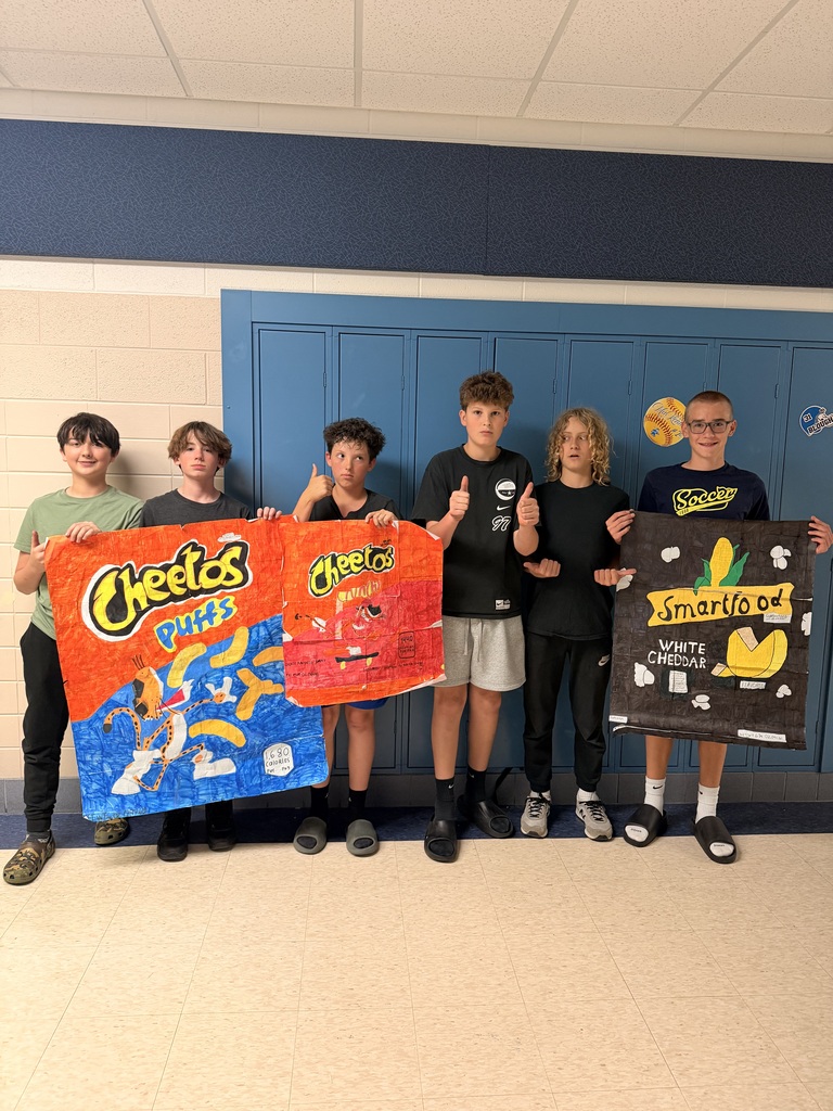 6 boys holding giant drawings of Cheetos and Smartfood bags