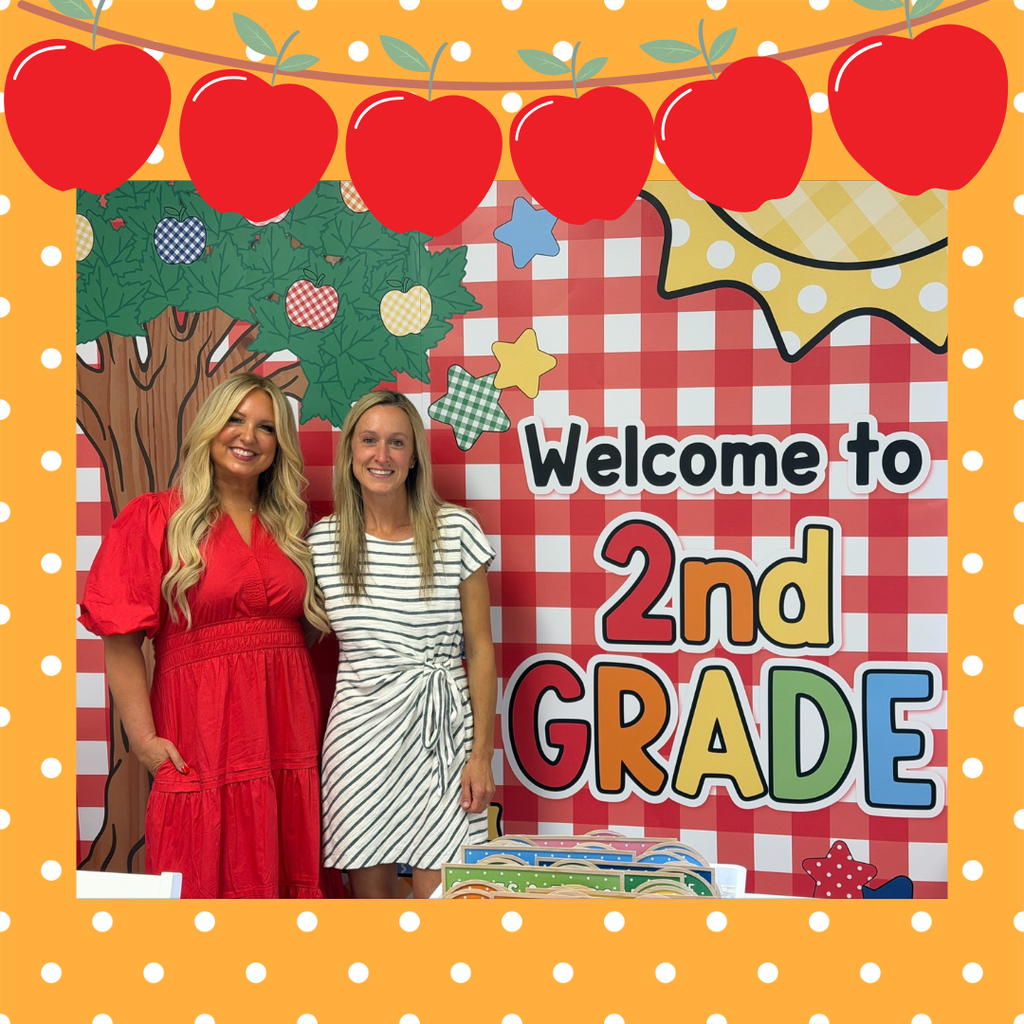 2 women posing in front of a Welcome to 2nd Grade Sign