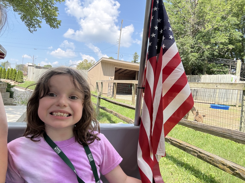 girl smiling next to an american flag