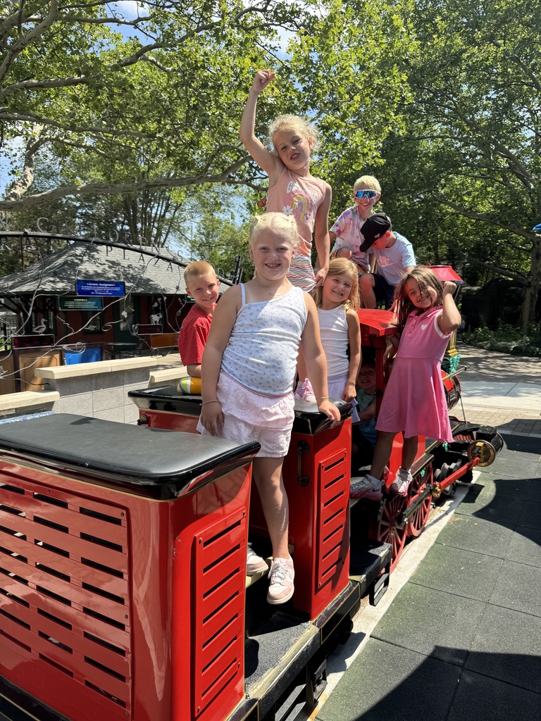 children posing on a small red train