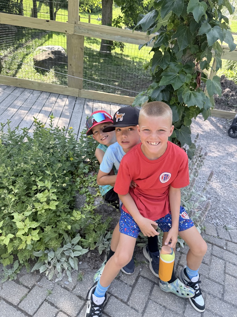3 boys posing at a zoo