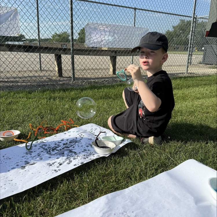 little boy playing outside with bubbles