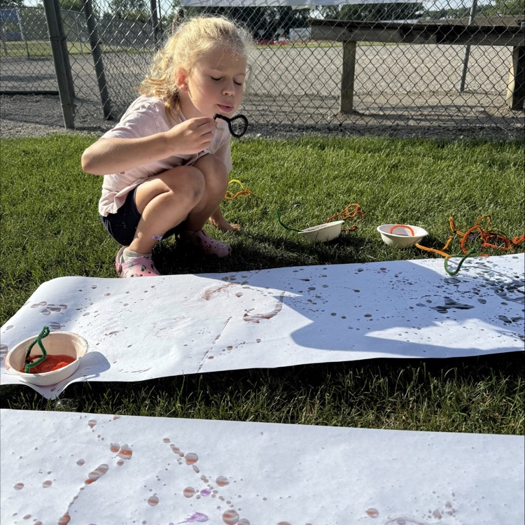 little girl playing outside with bubbles