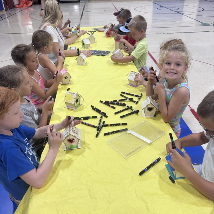 a table full of kids doing crafts