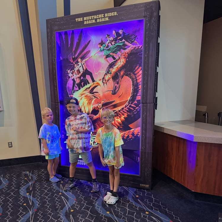 kids posing in front of a movie poster