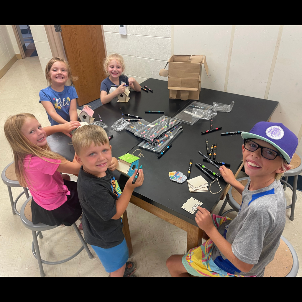 kids sitting at a table drawing