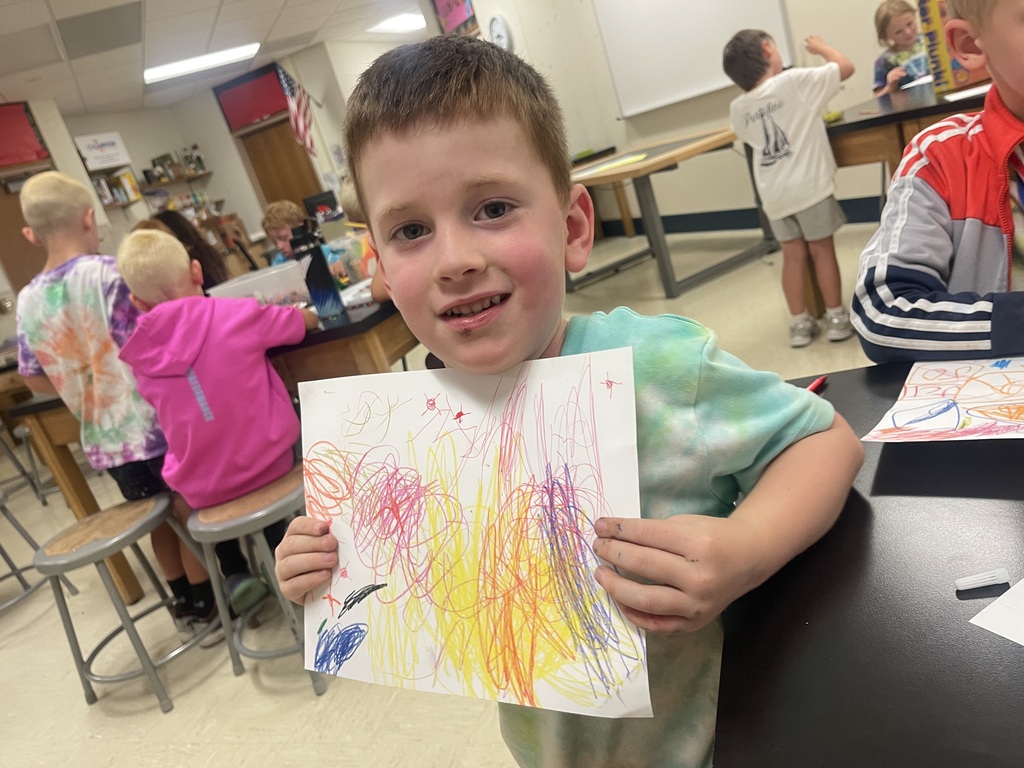 little boy holding up drawing