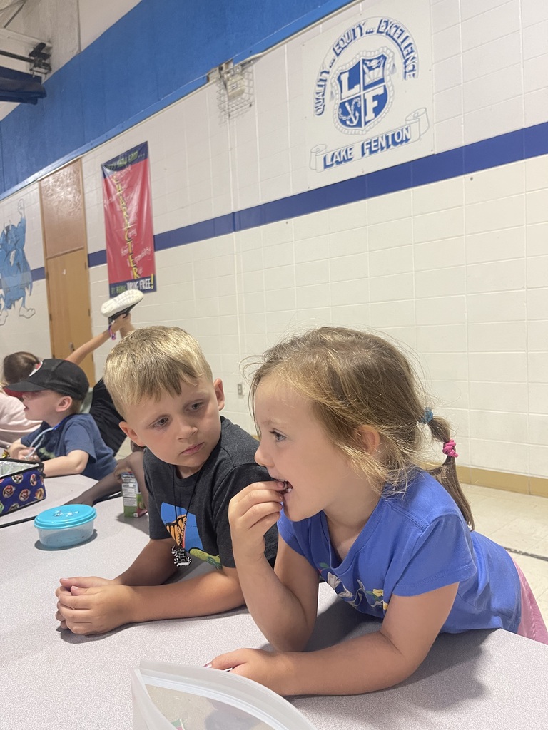little boy looking at a little girl eating