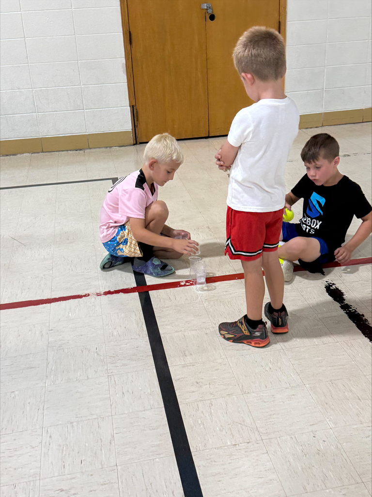 kids playing with cups on a gym floor