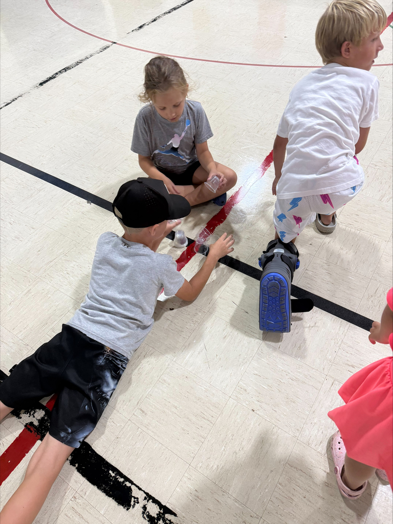 kids playing with cups on a gym floor