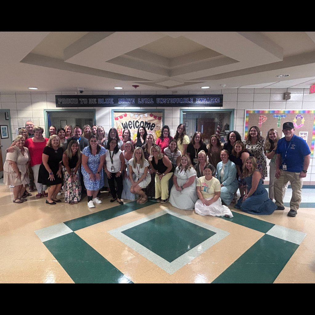 large group of people posing inside a school
