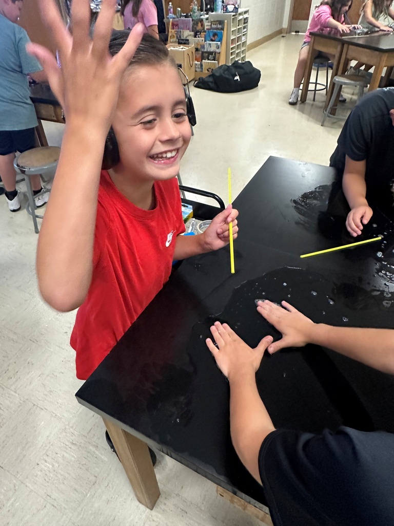 student making large bubbles on a black table