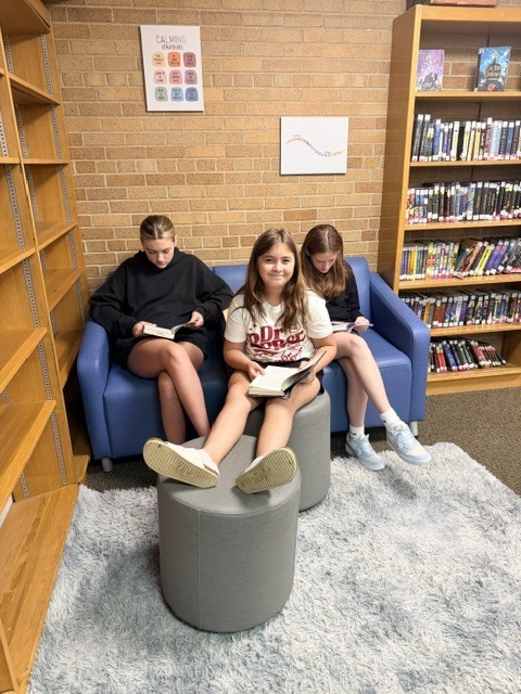 3 girls reading in a library