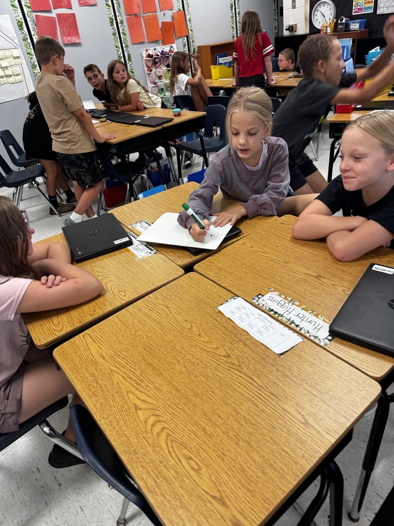 classroom full of kids sitting around desks