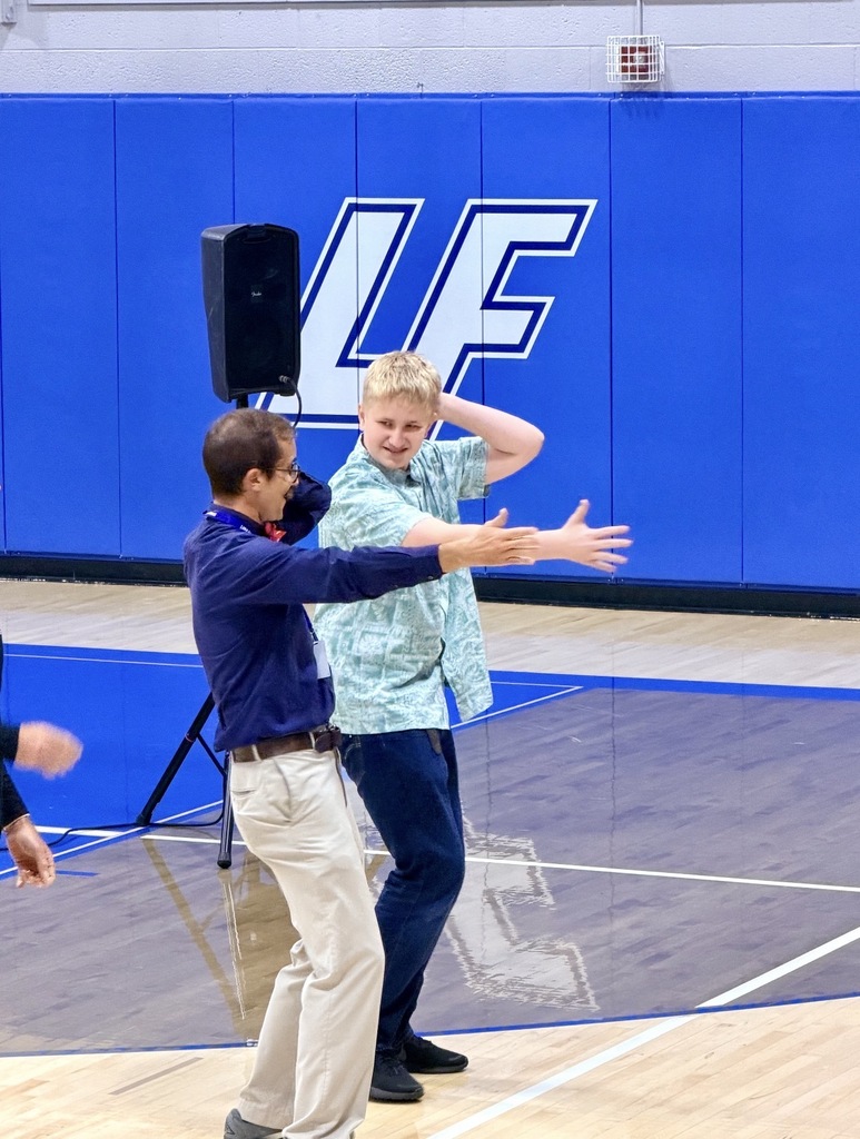 teacher and student dancing in a gym