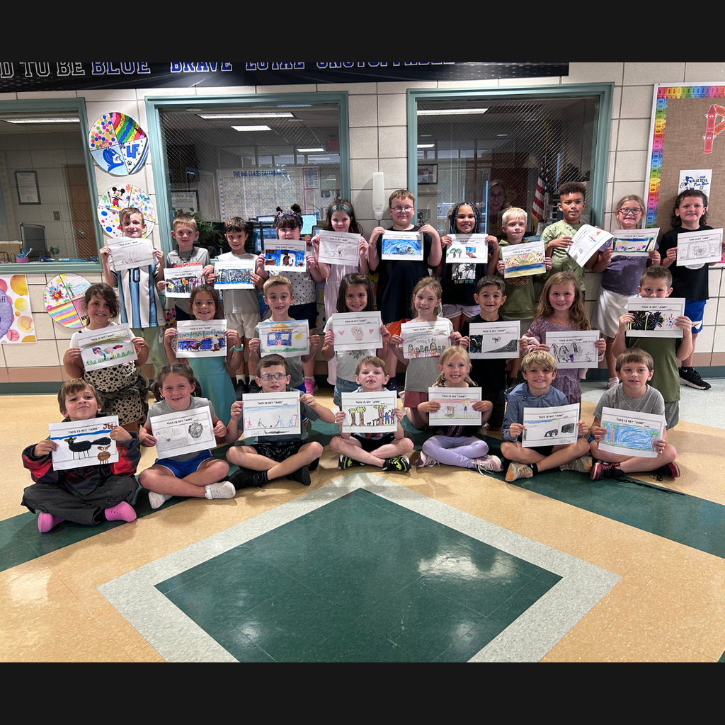 class of children holding drawings