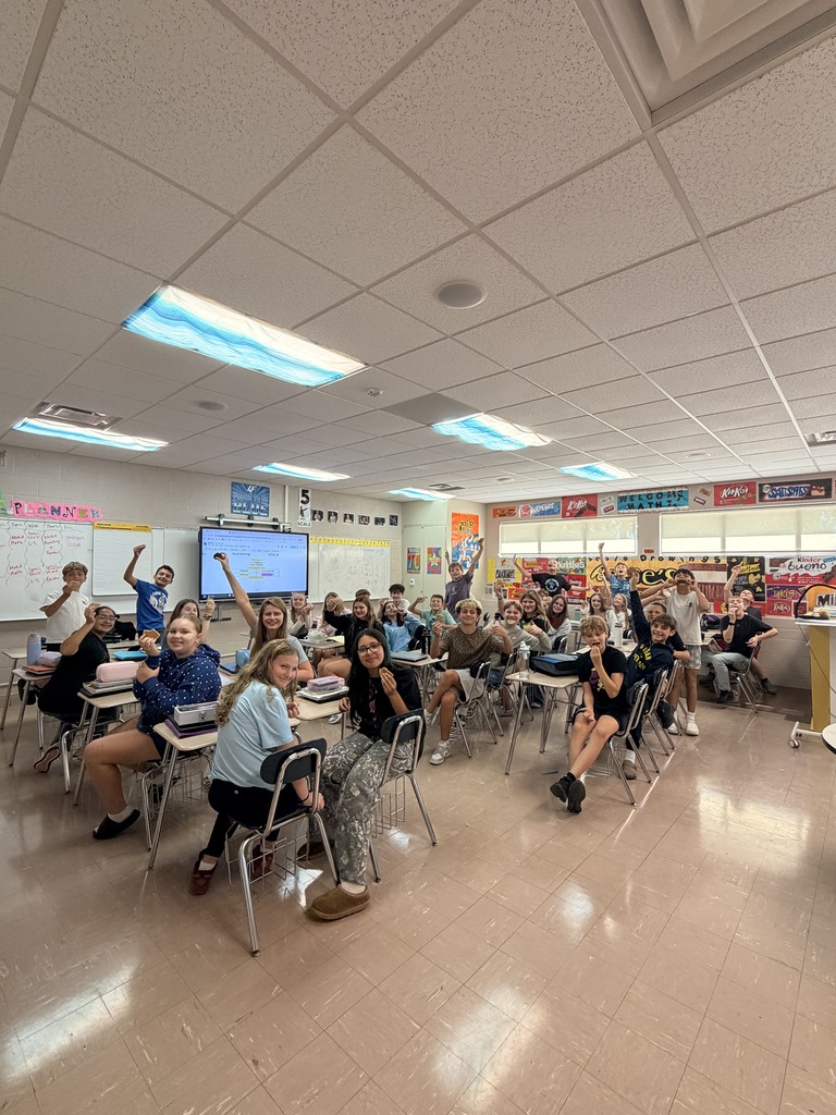 classroom of kids holding up cookies