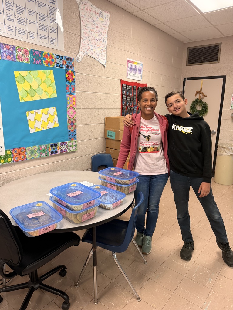boy and woman standing near a table with cookies on it