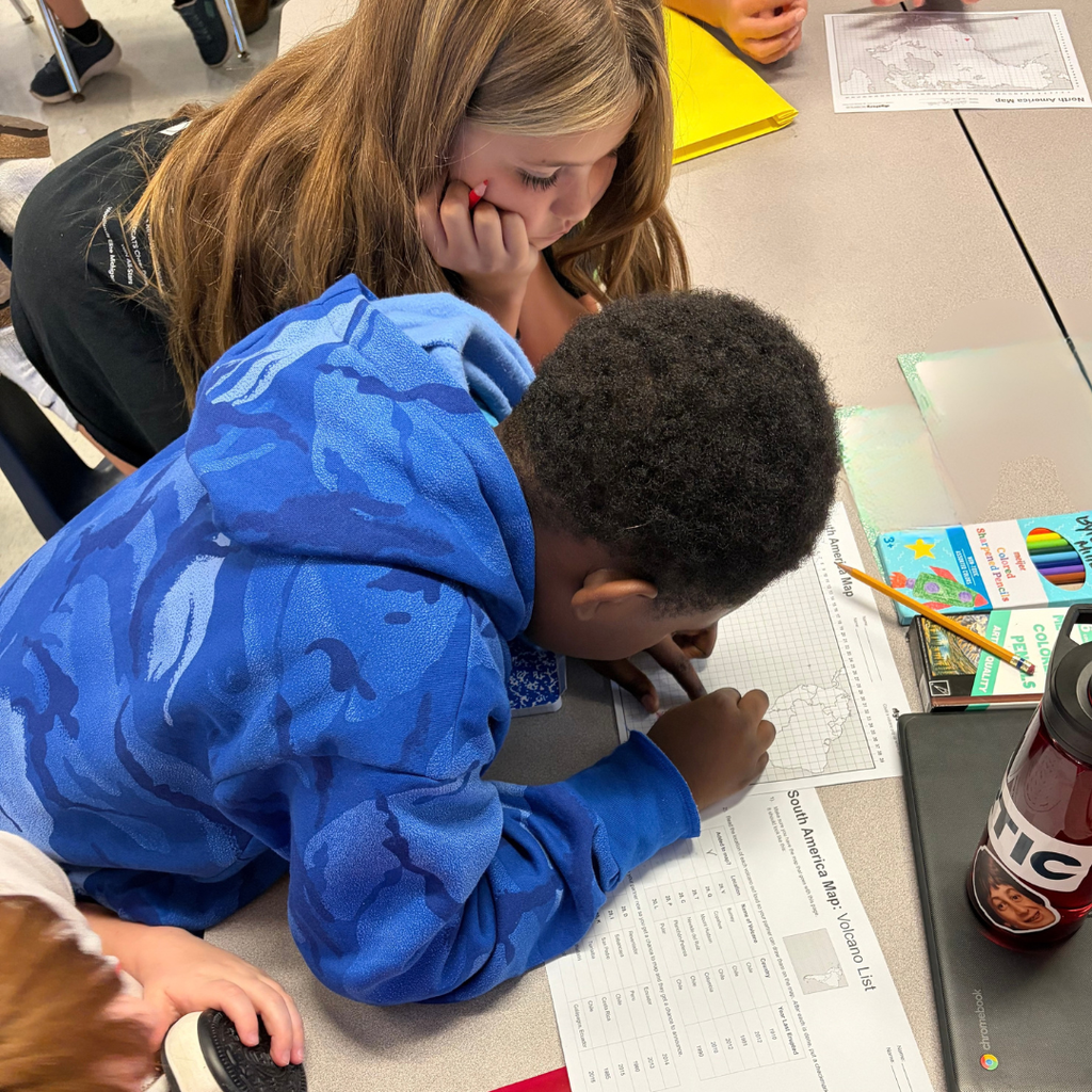 2 kids sitting at a desk doing homework