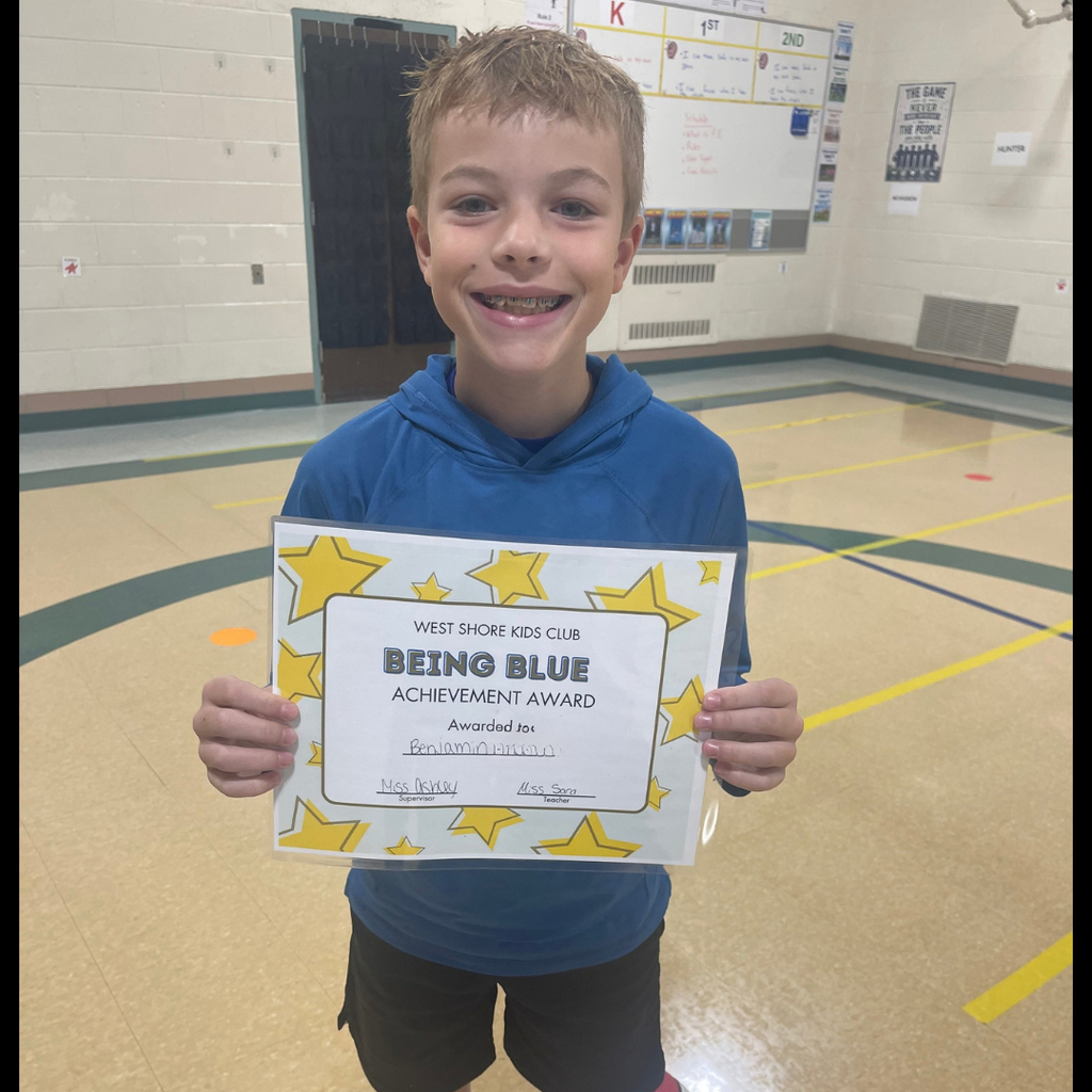 Boy smiling and holding a Being Blue Achievement Certificate