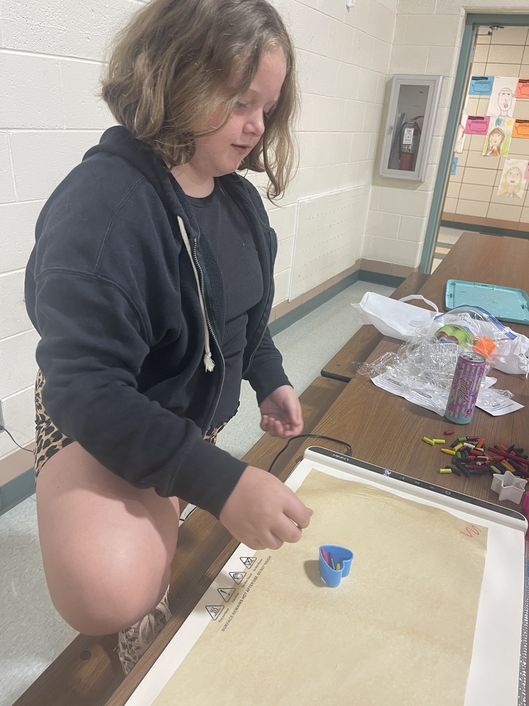 picture of a boy using cookie cutters with melted crayons