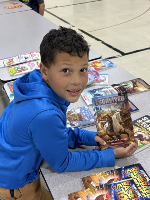 boy holding a dinosaur book