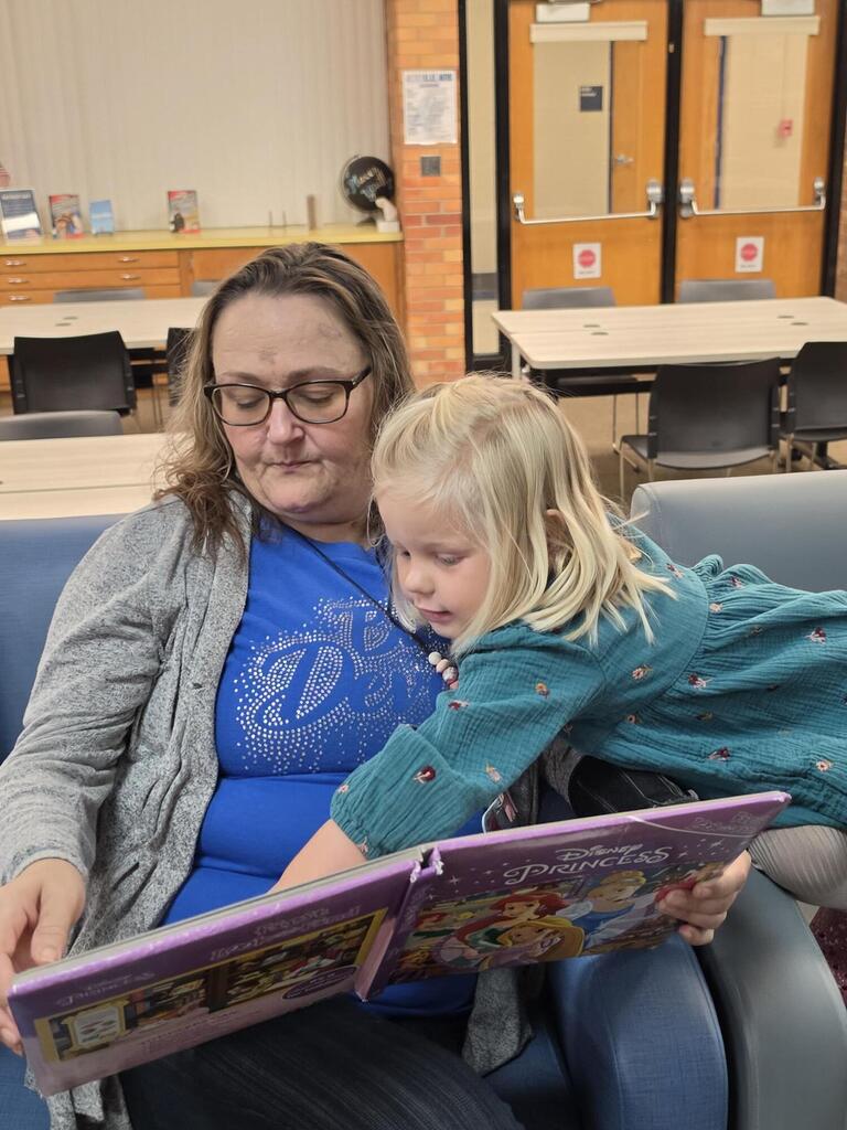 girl reading a book to a woman