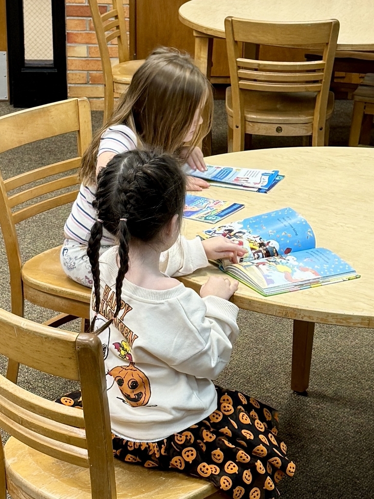 2 girls reading at a table