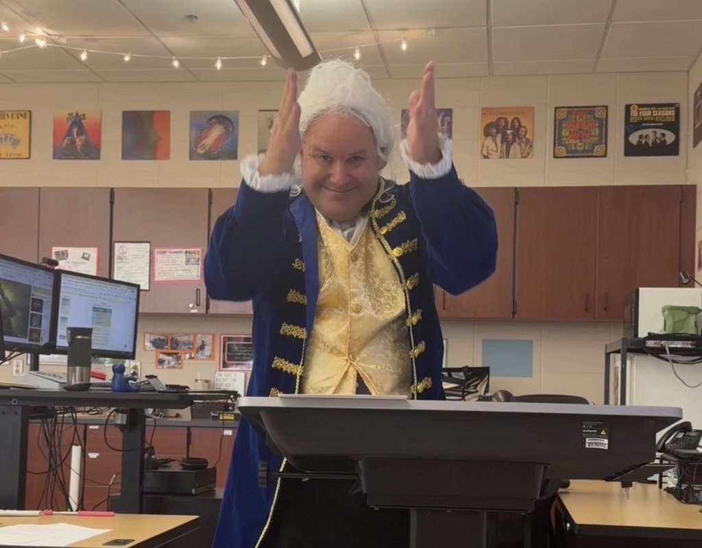 man  dressed like James Madison at the head of a classroom