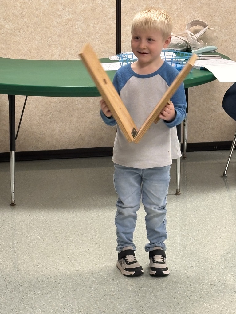 a boy playing with slapsticks in music class
