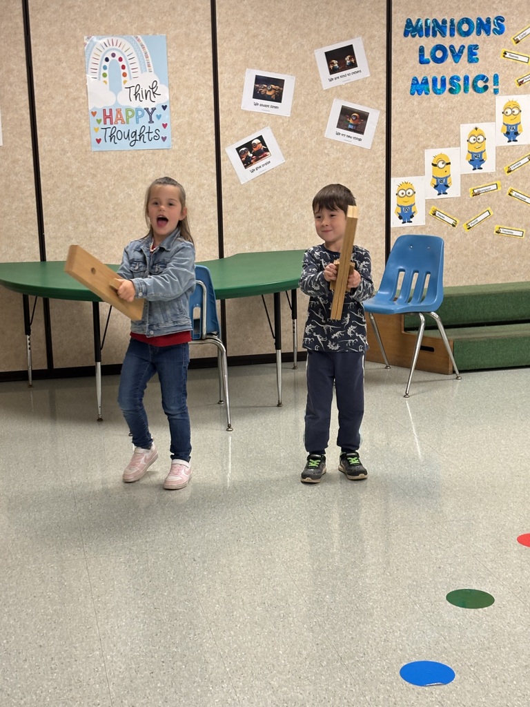 2 children playing with slapsticks in music class