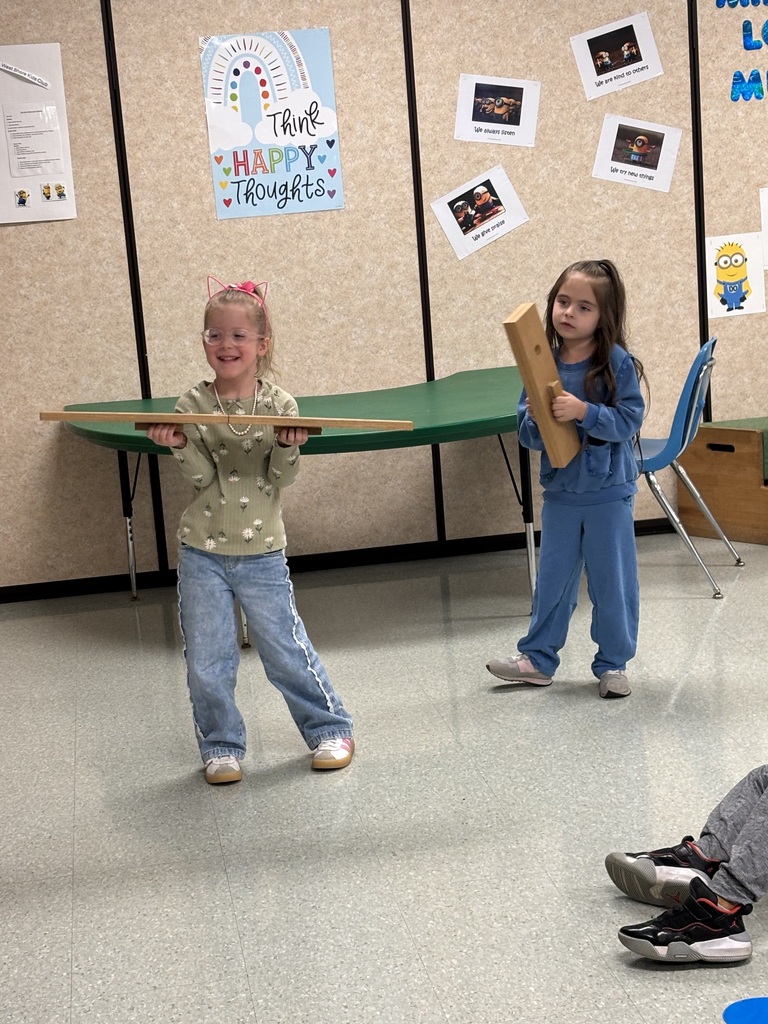 2 children playing with slapsticks in music class