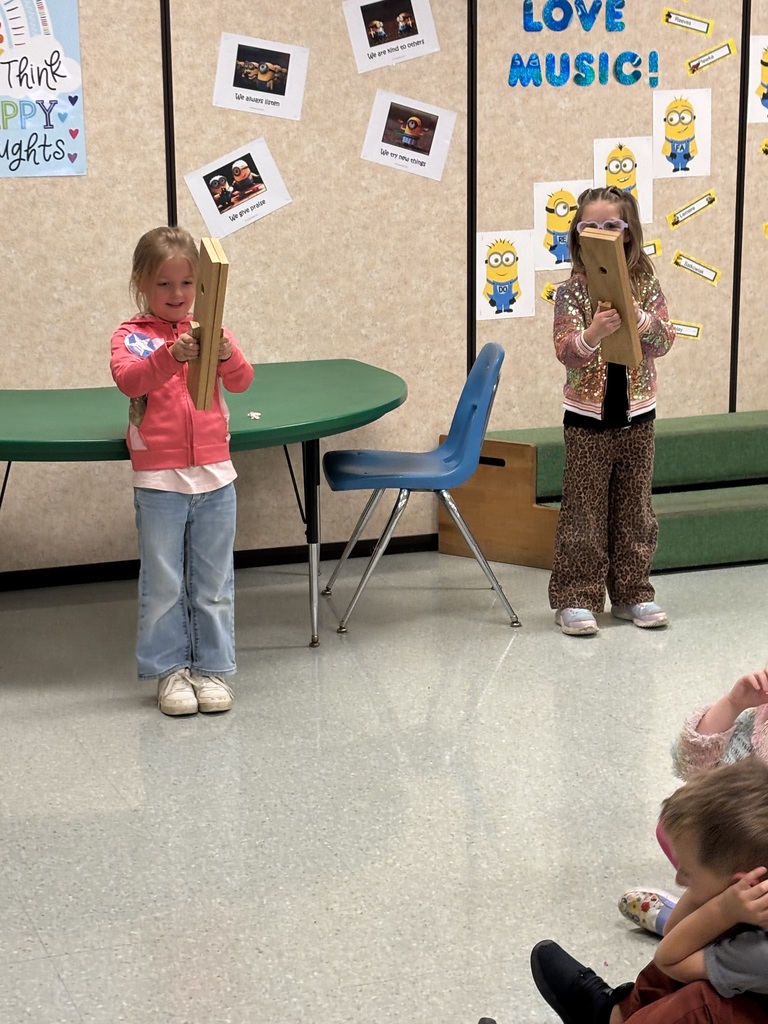 2 children playing with slapsticks in music class