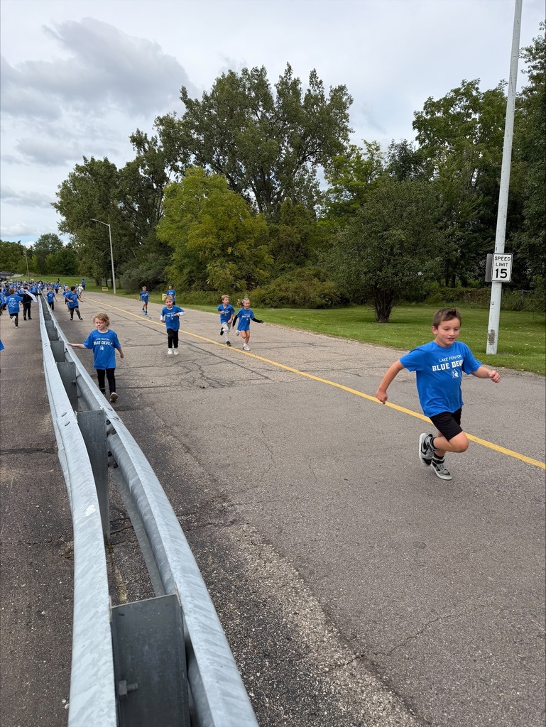group of children running wearing blue tshirts