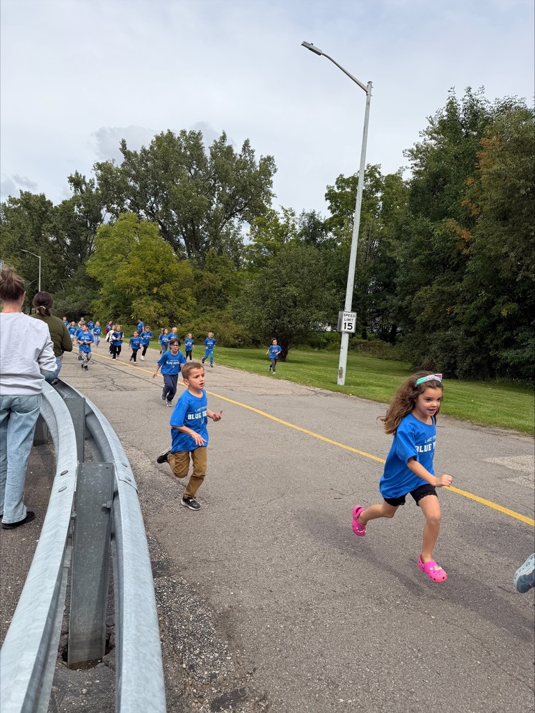 group of children running wearing blue tshirts