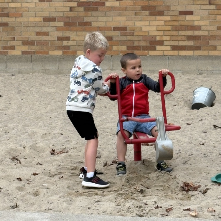2 boys digging in sand